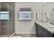 Bathroom featuring a glass enclosed shower, granite counters and a window providing natural light at 12848 Hilary St, Spring Hill, FL 34609