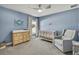 Cozy Bedroom with calming blue walls, crib, dresser, comfy chair, and ample natural light at 12848 Hilary St, Spring Hill, FL 34609
