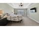 Light-filled bedroom featuring a tray ceiling, fan with lights, carpet, and an exterior door at 12848 Hilary St, Spring Hill, FL 34609