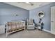 Inviting Bedroom painted in blue tones includes a crib, comfortable chair, and nautical-themed decor at 12848 Hilary St, Spring Hill, FL 34609