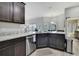 Modern kitchen featuring granite countertops, stainless steel appliances, and gray wood-look floors at 12848 Hilary St, Spring Hill, FL 34609