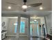 View of the gray living room featuring a modern ceiling fan and an abundance of natural light at 12848 Hilary St, Spring Hill, FL 34609