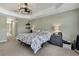 Main bedroom features soft green walls, carpet floors, and a decorative ceiling fan at 12848 Hilary St, Spring Hill, FL 34609