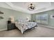 Main bedroom features a floral patterned bed, soft green walls, and a decorative ceiling fan at 12848 Hilary St, Spring Hill, FL 34609