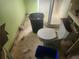 Dilapidated bathroom with toilet, bucket, and damaged flooring needing renovation at 13120 Davista Ave, New Port Richey, FL 34654