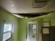 Damaged bathroom featuring a shower, cracked ceiling, and outdated green walls at 13120 Davista Ave, New Port Richey, FL 34654