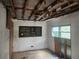 Interior view of a bedroom with a boarded up window and no flooring at 13120 Davista Ave, New Port Richey, FL 34654