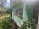Dilapidated mobile home with peeling green paint, lattice, and outdated windows needing restoration at 13120 Davista Ave, New Port Richey, FL 34654