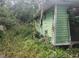 Weathered mobile home covered in overgrown vegetation showing signs of disrepair and neglect at 13120 Davista Ave, New Port Richey, FL 34654