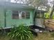 Dilapidated mobile home with peeling green paint, lattice, and outdated windows needing restoration at 13120 Davista Ave, New Port Richey, FL 34654