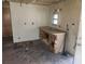 Damaged kitchen with a double basin sink and storage, showing signs of disrepair and neglect at 13120 Davista Ave, New Port Richey, FL 34654