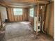 Living room showing exposed studs, plywood walls, and a newer water heater at 13120 Davista Ave, New Port Richey, FL 34654