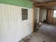 Unfinished living room with siding, exposed studs, plywood walls and an open doorway at 13120 Davista Ave, New Port Richey, FL 34654