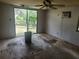 A living room requiring extensive repairs features broken windows, damaged floors, and walls at 13120 Davista Ave, New Port Richey, FL 34654