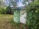 Image of an old outbuilding with a closed white door and green siding at 13120 Davista Ave, New Port Richey, FL 34654