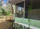 Exterior side view of the screened-in porch with lattice and vine details at 13120 Davista Ave, New Port Richey, FL 34654