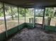 A view of the screened-in porch with an entry door and outdoor view at 13120 Davista Ave, New Port Richey, FL 34654