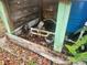 Close up of the well's pump and pipes, with ferns and a blue water tank at 13120 Davista Ave, New Port Richey, FL 34654