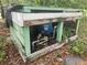 Close up of the well's pump and pipes, with ferns and a blue water tank at 13120 Davista Ave, New Port Richey, FL 34654