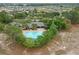 Aerial view of a community pool surrounded by lush trees and homes in a well-maintained neighborhood at 13619 Hunters Point St, Spring Hill, FL 34609