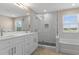 A bright bathroom with a double vanity, a shower, and a tub at 13619 Hunters Point St, Spring Hill, FL 34609