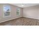Bedroom with wood-look flooring, bright windows, and neutral walls at 13619 Hunters Point St, Spring Hill, FL 34609