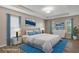 This bedroom features a tray ceiling, wood-look floors, and an ensuite bathroom at 13619 Hunters Point St, Spring Hill, FL 34609