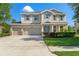 Inviting two-story home featuring a three-car garage, manicured lawn and charming curb appeal at 13619 Hunters Point St, Spring Hill, FL 34609
