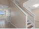 Bright hallway with staircase, neutral walls, and tiled flooring, leading to multiple rooms at 13619 Hunters Point St, Spring Hill, FL 34609