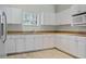 Well-lit kitchen featuring sleek white cabinets, neutral countertops, and modern appliances at 13619 Hunters Point St, Spring Hill, FL 34609