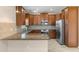 Open kitchen featuring a granite countertop, stainless appliances and wood cabinets at 13619 Hunters Point St, Spring Hill, FL 34609