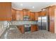Kitchen featuring granite countertops, modern appliances, and wood cabinets at 13619 Hunters Point St, Spring Hill, FL 34609
