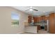 Modern kitchen features stainless steel appliances, wood cabinetry, and a breakfast bar overlooking the dining area at 13619 Hunters Point St, Spring Hill, FL 34609