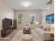 Stylishly staged living room with comfortable seating, a large window, and an elegant rug at 13619 Hunters Point St, Spring Hill, FL 34609
