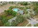An aerial view of the community pool and clubhouse surrounded by lush landscaping and neighborhood parking at 13619 Hunters Point St, Spring Hill, FL 34609