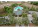 Aerial view of a community pool, clubhouse, parking lot, and lush landscaping at 13619 Hunters Point St, Spring Hill, FL 34609