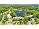 Community aerial shot with lush greenery, lake with fountain, and community pool at 1423 Pine Glen Ln # E2, Tarpon Springs, FL 34688