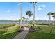 Landscaped backyard with manicured lawn and brick walkway leading to the water at 1473 Sail Harbor Cir, Tarpon Springs, FL 34689
