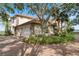 Charming home featuring a brick driveway, a three-car garage and mature trees surrounding the property at 1473 Sail Harbor Cir, Tarpon Springs, FL 34689