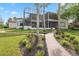 Exterior of home showing expansive screened in patio and landscaped grounds at 1473 Sail Harbor Cir, Tarpon Springs, FL 34689