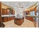 Spacious kitchen with wooden cabinetry, granite countertops, central island, and tiled floor at 1473 Sail Harbor Cir, Tarpon Springs, FL 34689