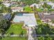 Aerial view of home with well-maintained lawn, landscaping, driveway and a screened pool at 155 Patty Ann Blvd, Palm Harbor, FL 34683