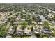 A beautiful aerial view showcases a charming neighborhood with lush tree cover and a tranquil pond at 155 Patty Ann Blvd, Palm Harbor, FL 34683