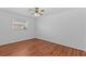 Empty bedroom with hardwood floors, a ceiling fan, and a bright window at 155 Patty Ann Blvd, Palm Harbor, FL 34683