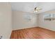 Bright bedroom with wood flooring, a ceiling fan, and natural light from two windows at 155 Patty Ann Blvd, Palm Harbor, FL 34683