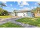Well-maintained single-Gathering home with an attached garage, beautiful landscaping, and manicured front lawn at 155 Patty Ann Blvd, Palm Harbor, FL 34683