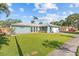 Charming single-story home with a lush green lawn, beautiful landscaping, and a welcoming front entrance at 155 Patty Ann Blvd, Palm Harbor, FL 34683