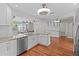 Bright kitchen with white cabinets, granite countertops, stainless appliances, and wood-look flooring at 155 Patty Ann Blvd, Palm Harbor, FL 34683