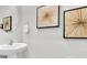 Close-up of a bathroom sink, mirror, and decorative artwork giving it a modern flair at 16177 Glowing Grove Ave, Odessa, FL 33556