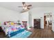 Bright bedroom with hardwood floors, ceiling fan, and closet, with an open doorway into another room at 1641 Bayfield Ct, Trinity, FL 34655